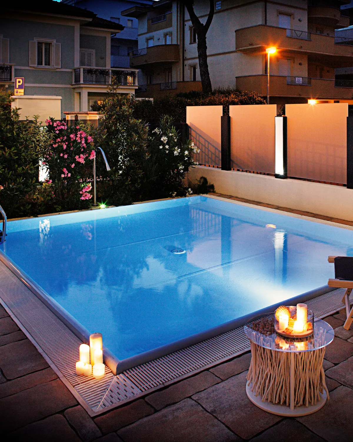 La piscina del D-Place al tramonto, con le candele accese sul bordo