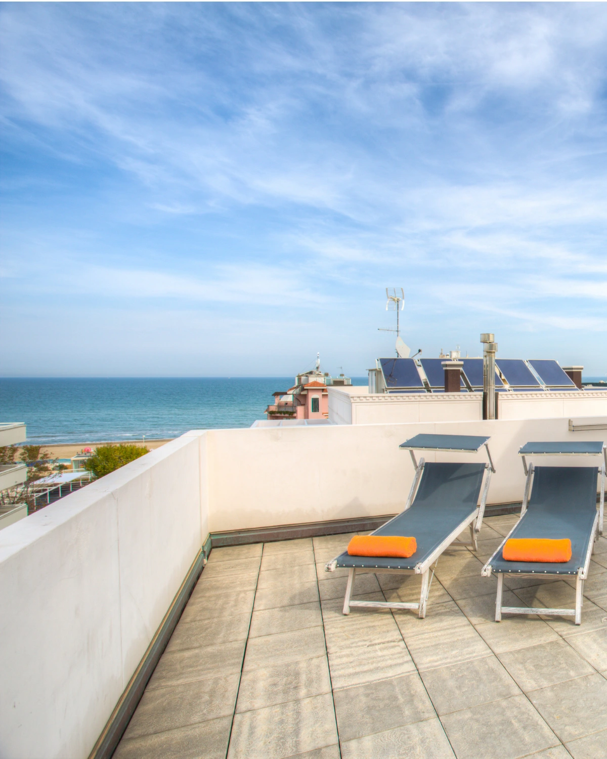 Il terrazzo con i due lettini e il mare di Riccione all’orizzonte
