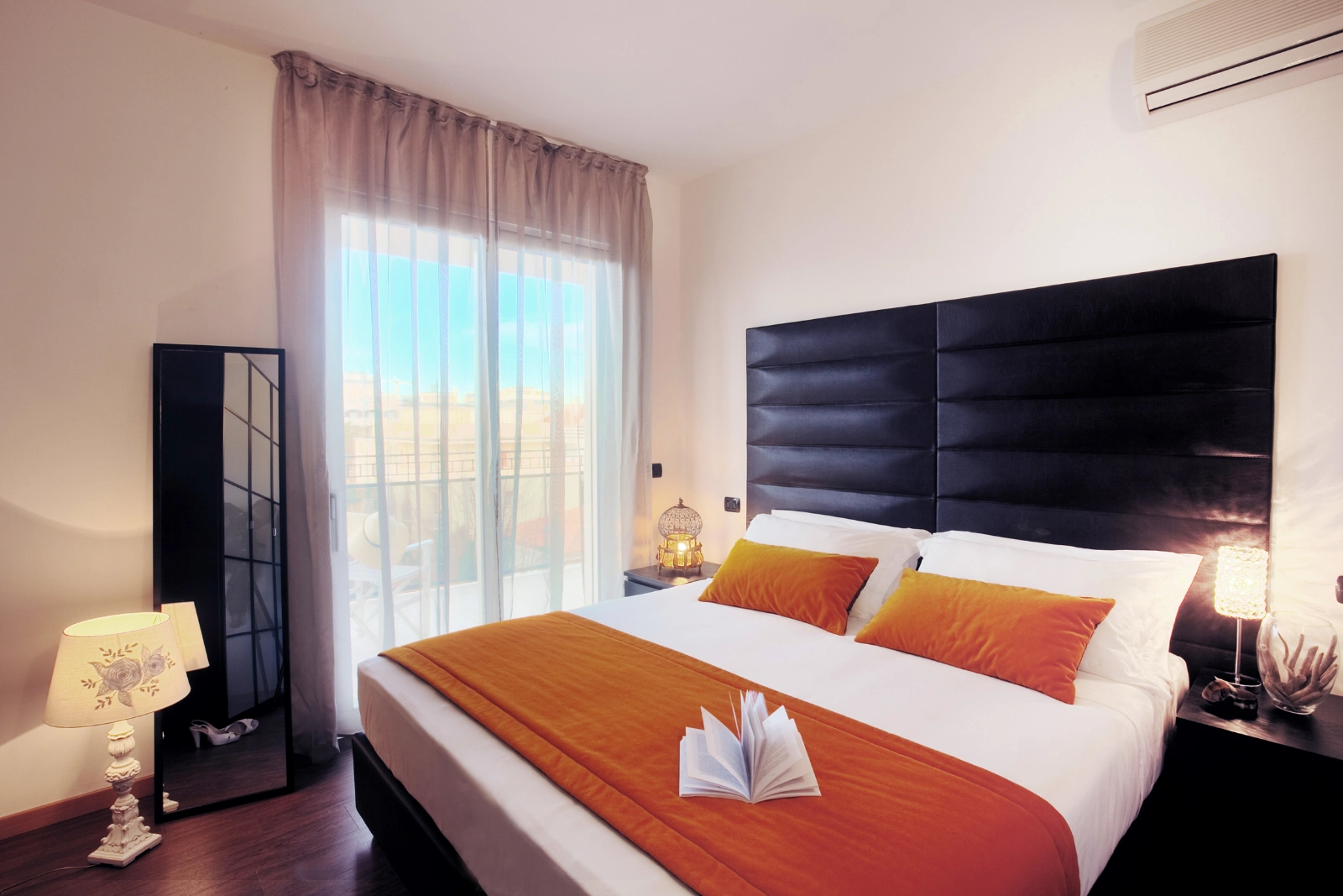 La camera da letto della D-two Suite, con la testata scura e la portafinestra sul terrazzo